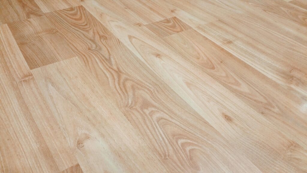 Smooth light brown wooden flooring with natural texture and patterns.